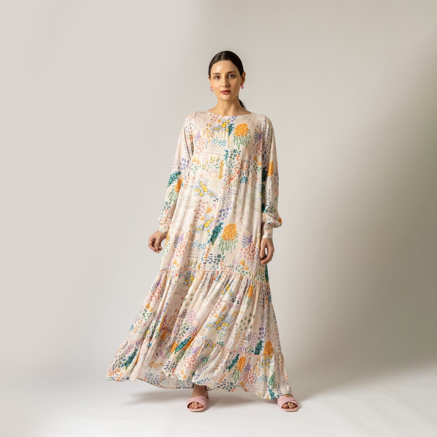 Doodlage Yayoi printed dress featuring colorful floral patterns and a flowing silhouette, displayed on a hanger.