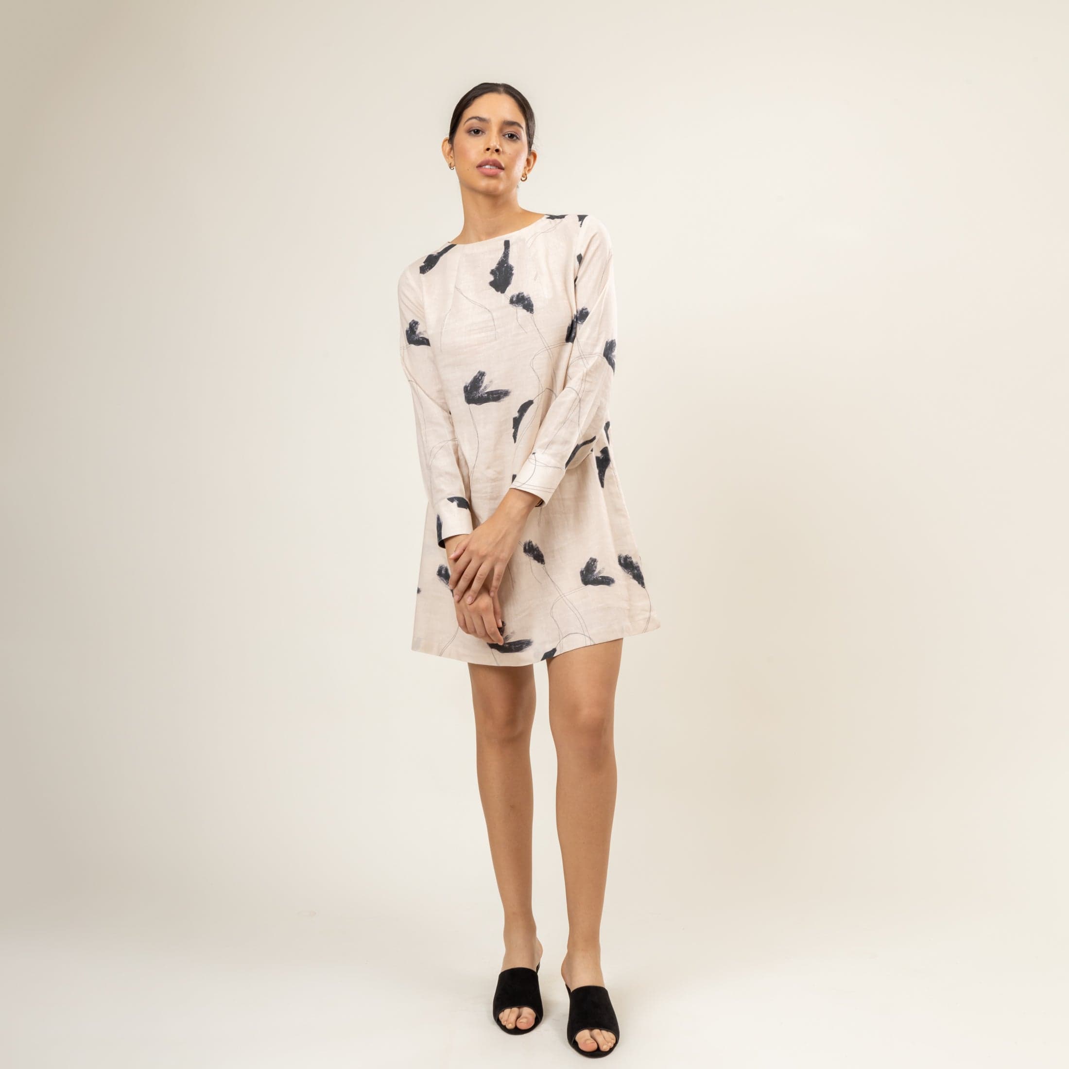 Carrie printed dress by Doodlage featuring colorful patterns and a flowy silhouette, worn by a model standing outdoors.