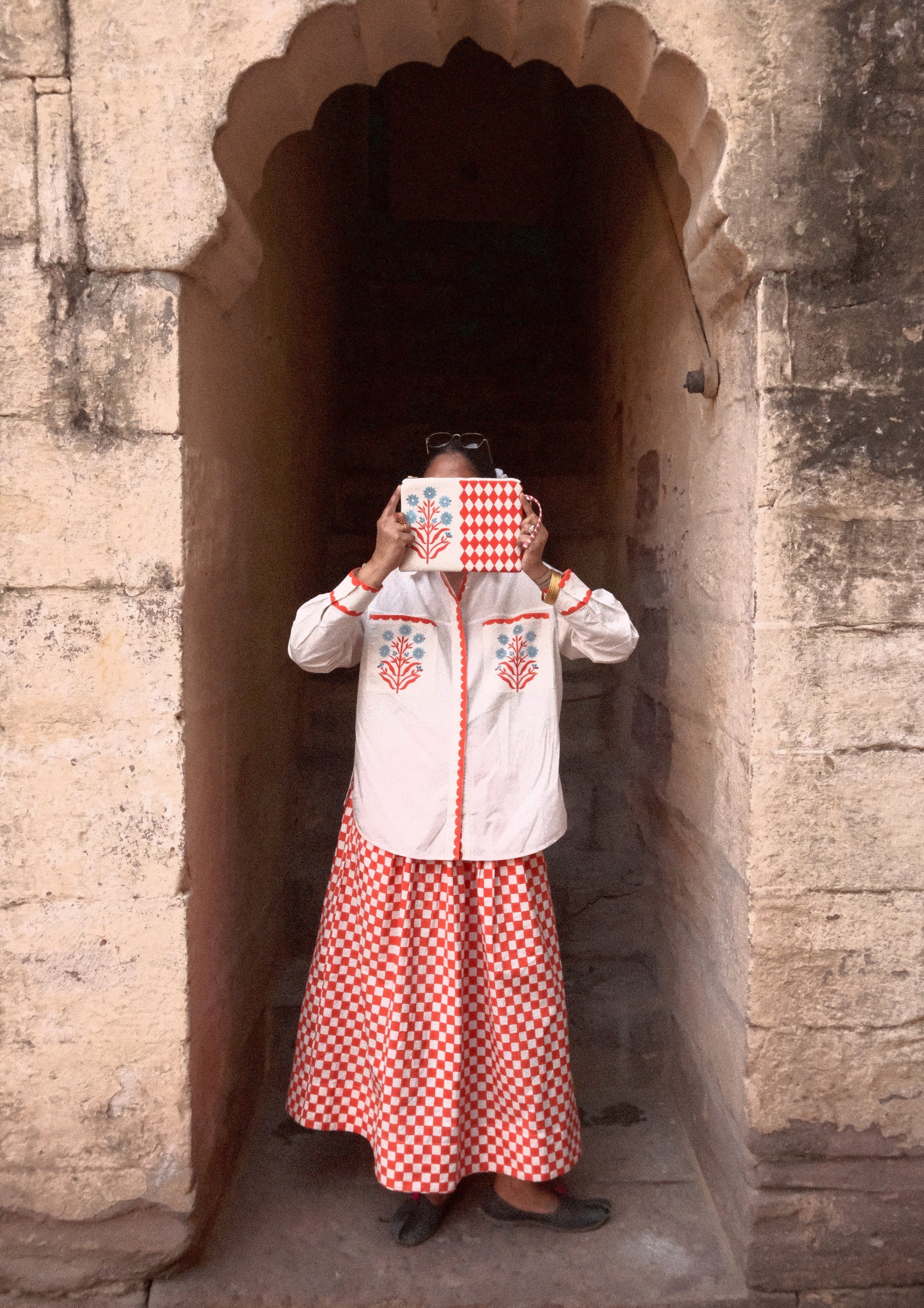 Red checked Bawari skirt from The Raw India featuring traditional Indian design and flowing fabric.