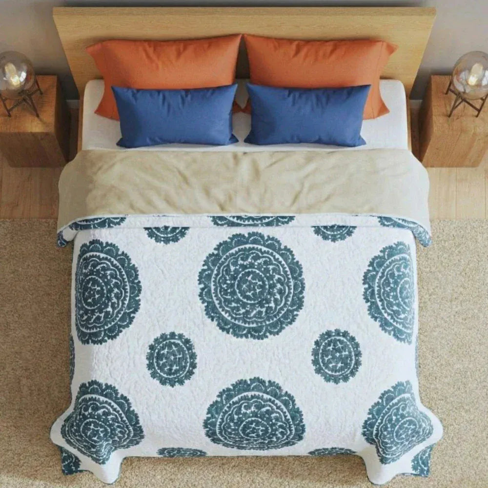 Gray Suzani quilt by Bombaybirds, showcasing intricate traditional embroidery and vibrant patterns on a cozy living room setup.