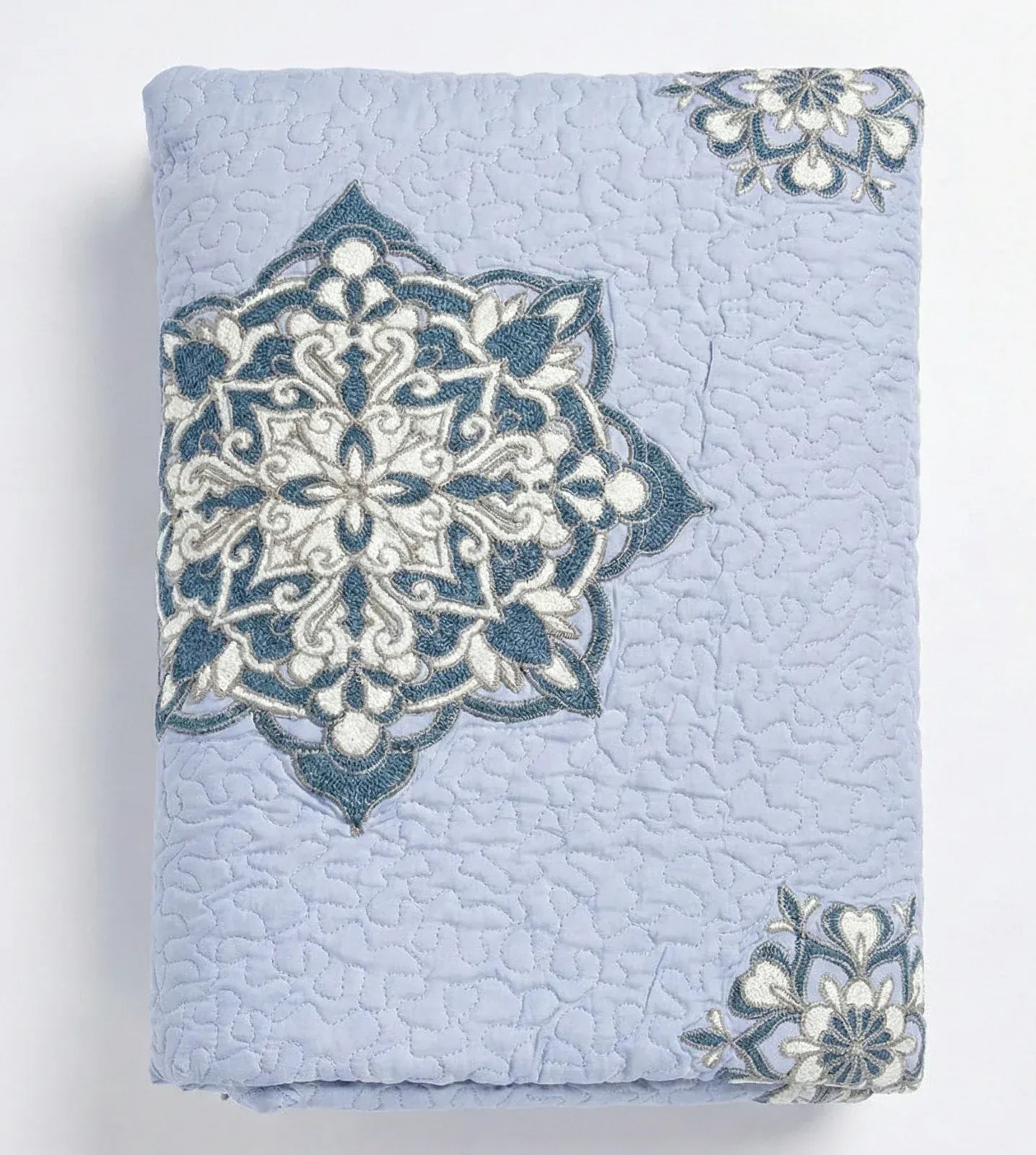 Lilac Suzani quilt from Bombaybirds, soft living room throw with intricate traditional embroidery and vibrant floral patterns.