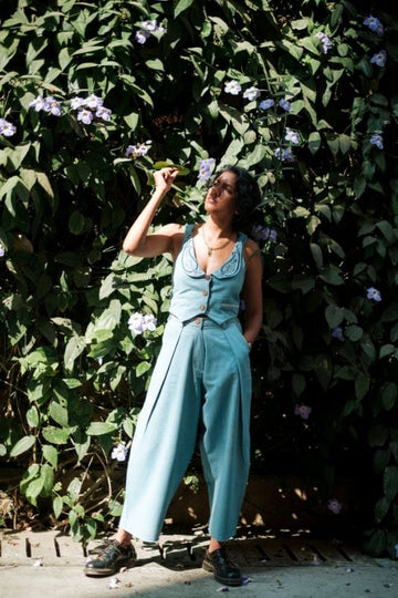 JODI handloom denim pleated trousers with a relaxed fit, showcasing the textured fabric and classic pleats in a natural pose.