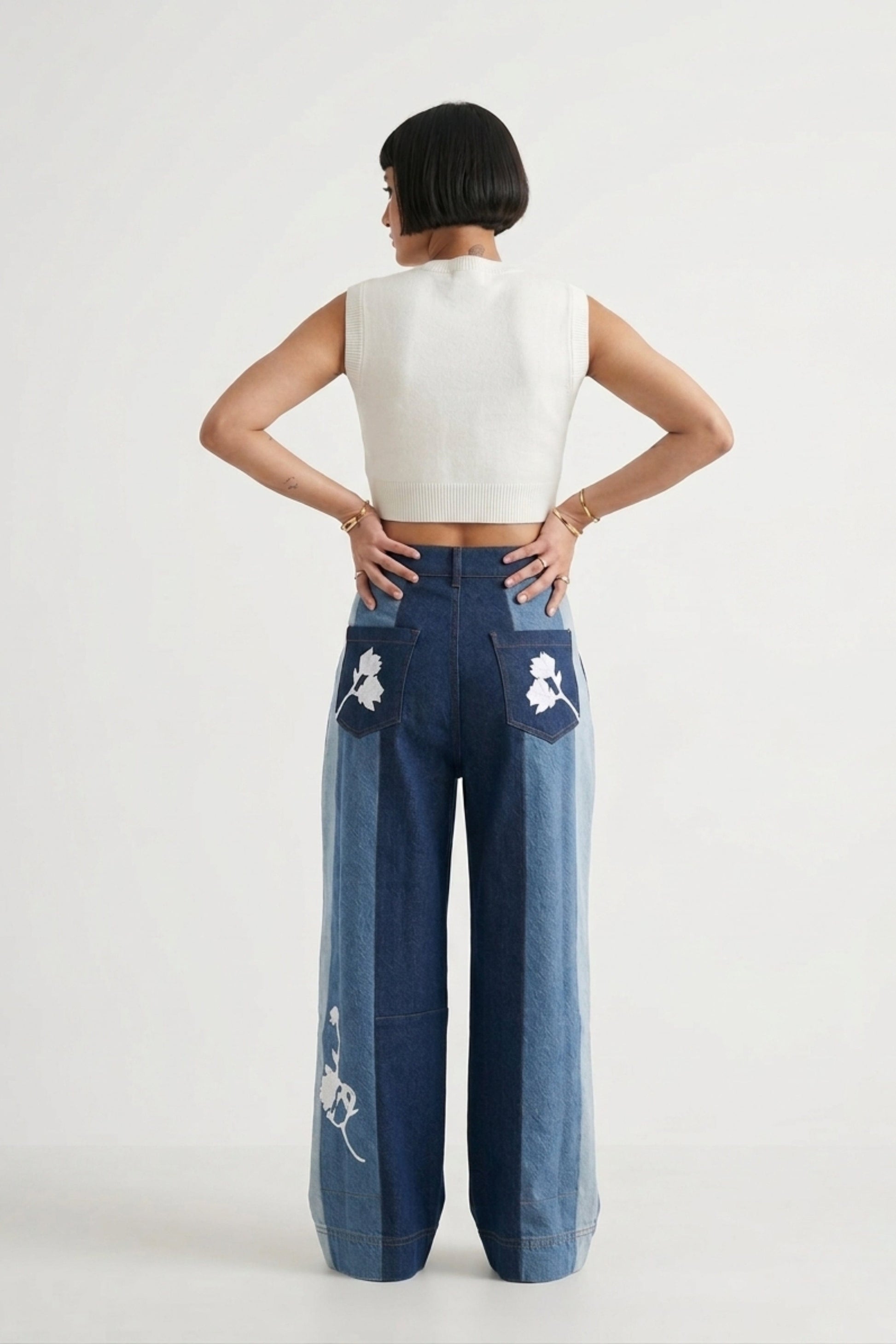 Doodlage Ember denim panelled pants showing a relaxed fit with patchwork and distressed detailing in blue denim fabric.