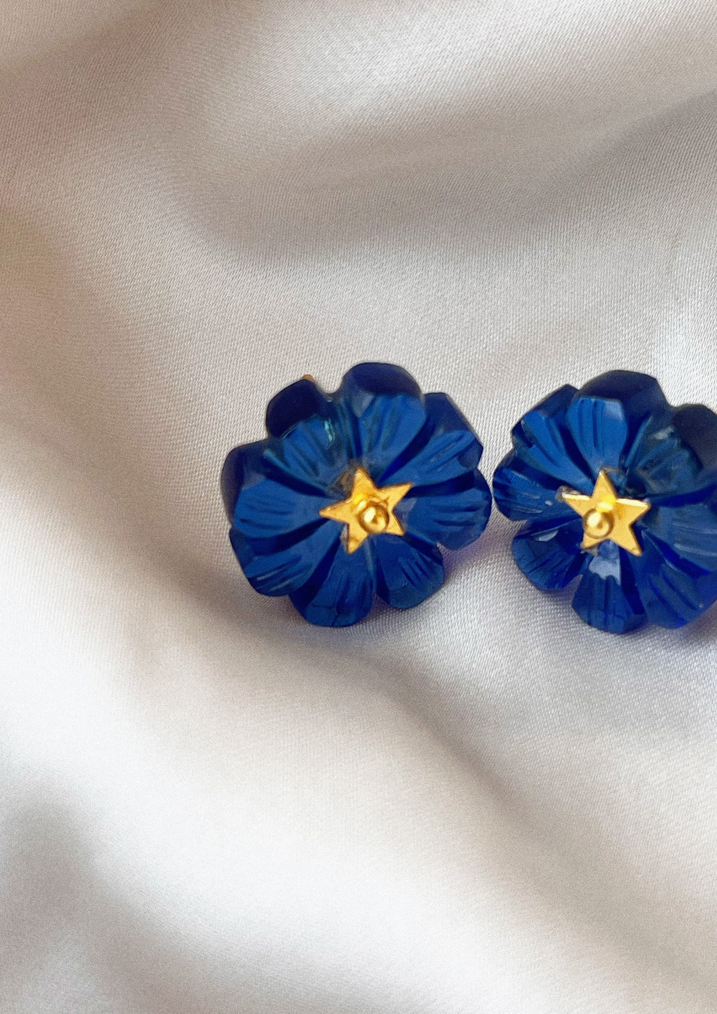 Blue quartz flower-shaped stud earrings from The Raw India, carved jewelry featuring delicate floral design.