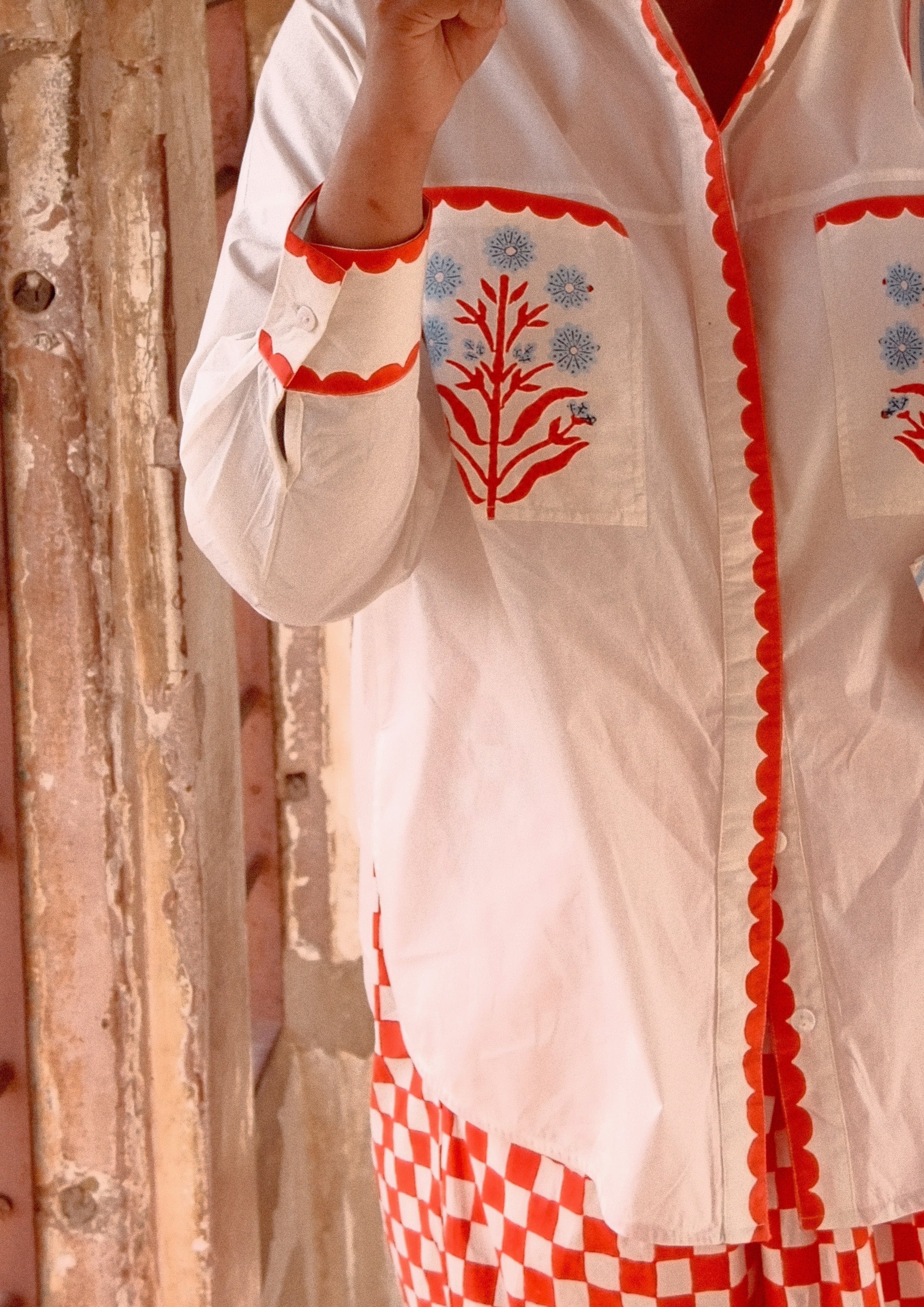 The Raw India Jaigarh shirt featuring Sambhar Buta print with traditional motifs in earthy tones, displayed on a hanger.