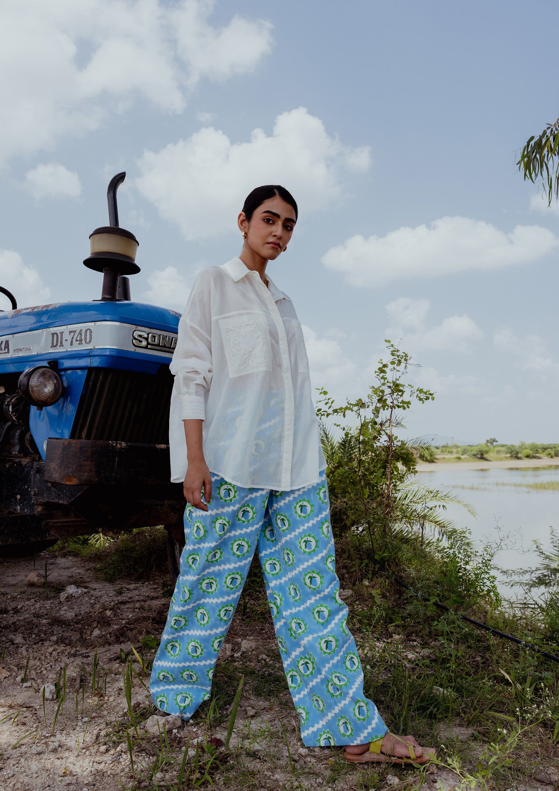The Raw India Amer Pants with Mango Block Print, featuring traditional woven patterns in earthy tones, displayed on a hanger.