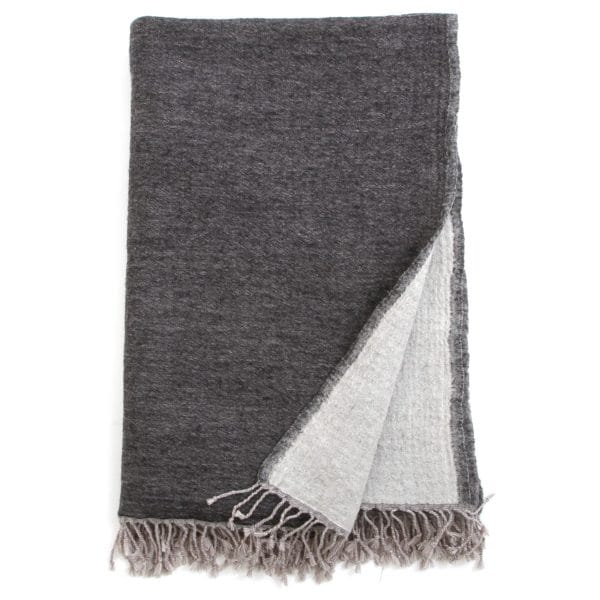 Charcoal and grey Bombaybirds living throw blanket draped over a sofa, showcasing soft, cozy fabric and modern design.