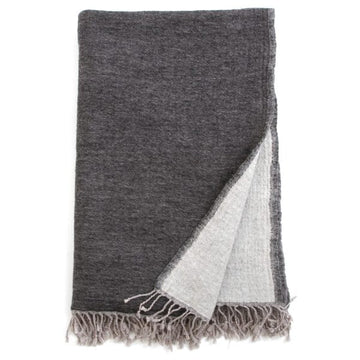 Charcoal and grey Bombaybirds living throw blanket draped over a sofa, showcasing soft, cozy fabric and modern design.