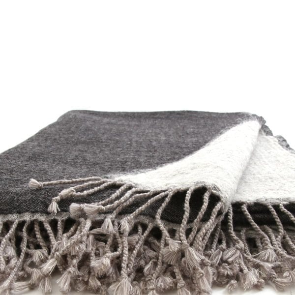 Charcoal and grey Bombaybirds living throw blanket draped over a sofa, showcasing soft, cozy fabric and modern design.
