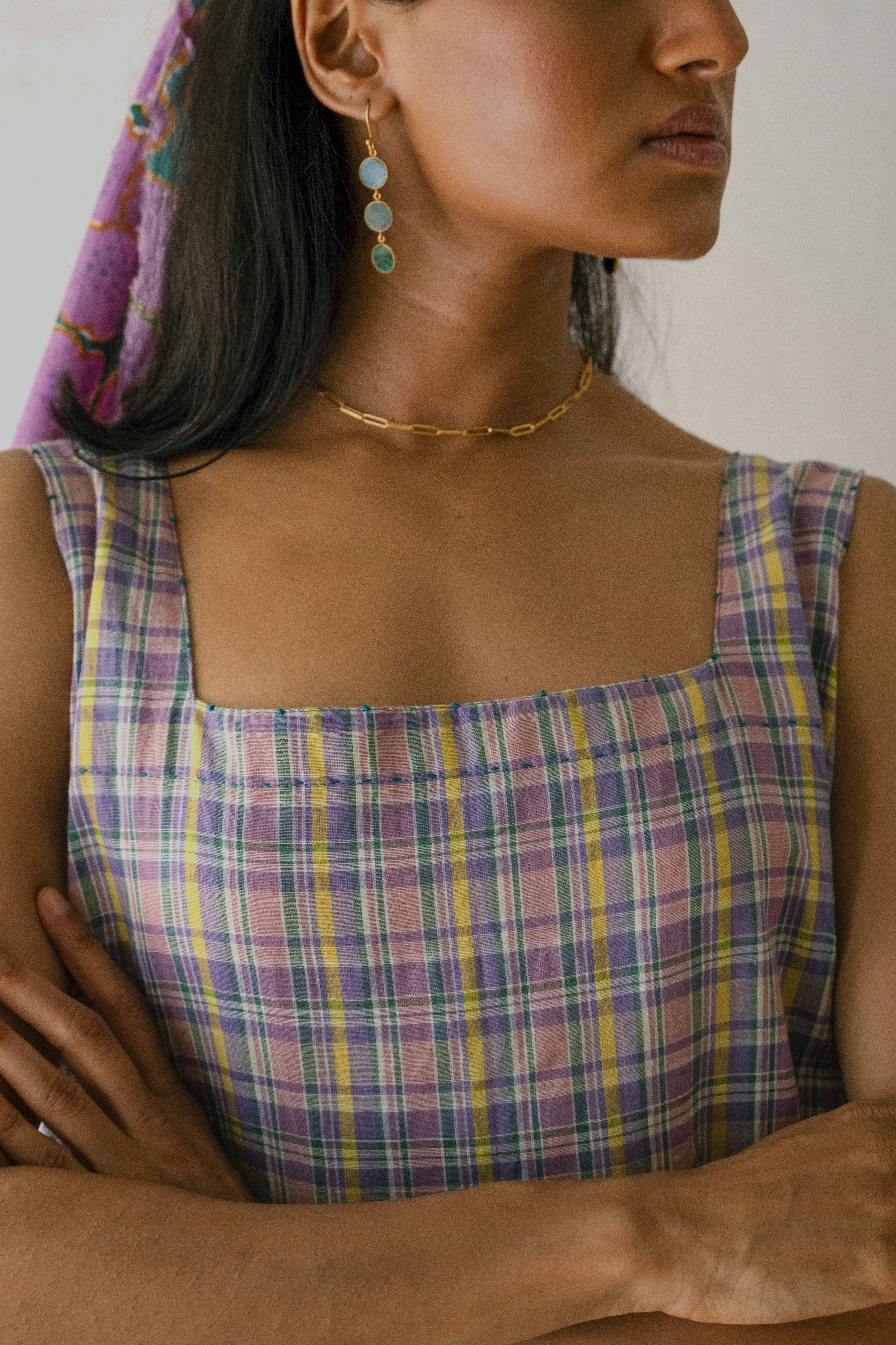 Deeta Meadow dress shown on a hanger, featuring a flowy fabric with floral patterns and a fitted bodice.