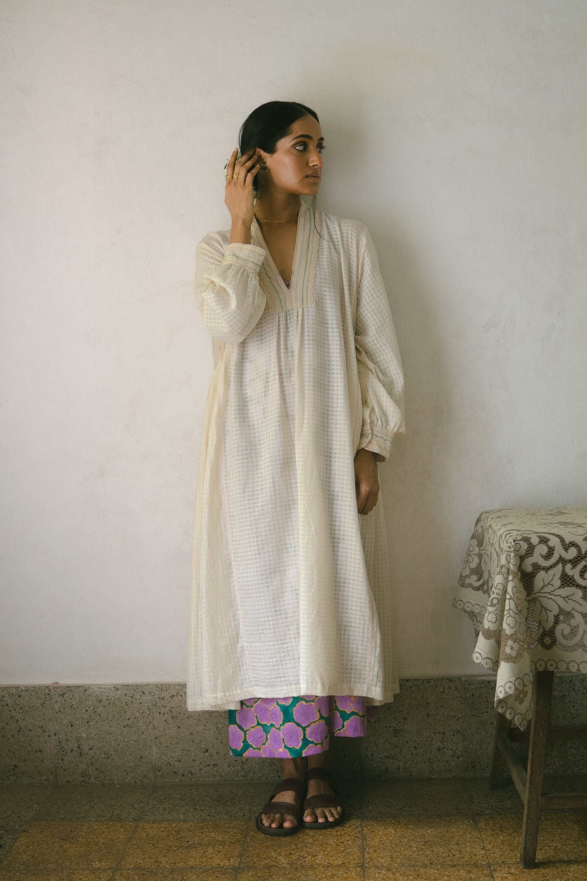 Deeta Noor dress displayed on a hanger, showcasing its elegant design and fabric details in natural lighting.