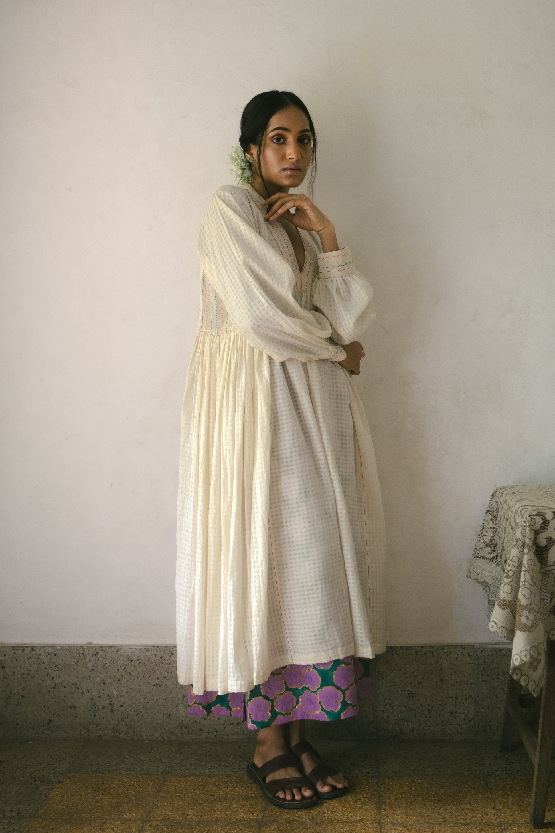Deeta Noor dress featuring a flowing fabric and intricate design, displayed on a hanger against a neutral background.