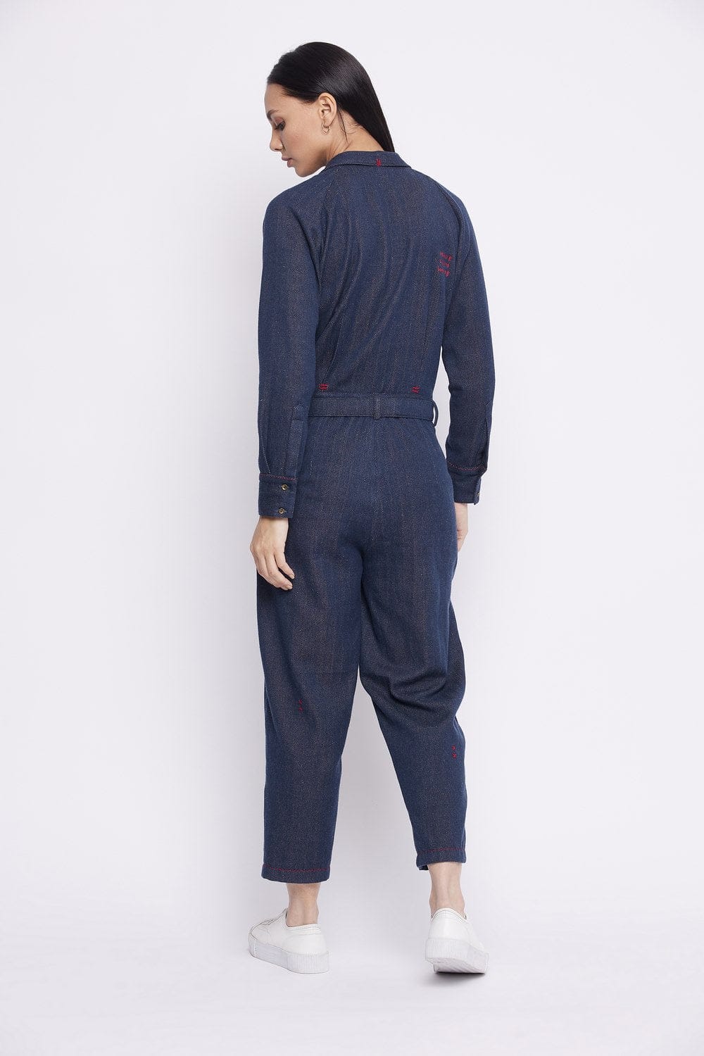 Upcycled denim jumpsuit by Doodlage featuring a relaxed fit, front pockets, and adjustable straps, styled with rolled-up cuffs.