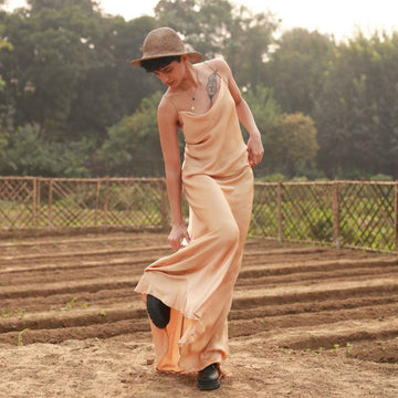 Doodlage Lola beige dress shown on a hanger, featuring a flowy fabric and simple, elegant design.