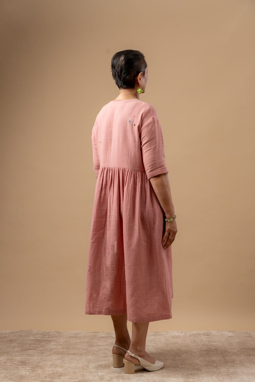 Doodlage Kara rose dress, lightweight fabric with floral pattern, short sleeves, and knee-length design on a hanger.
