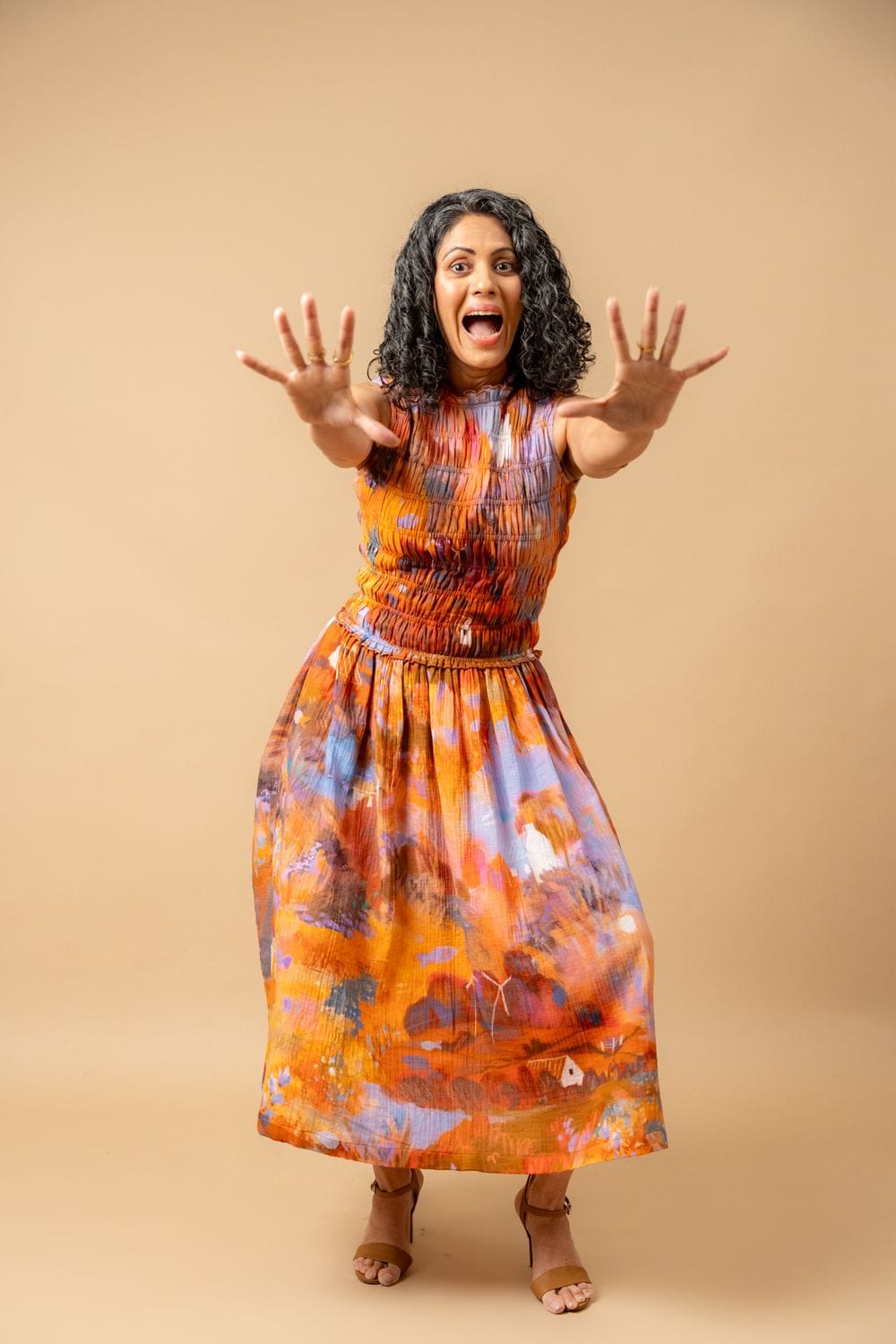 Doodlage Midsummer smocked dress in lightweight fabric with floral pattern and ruffled sleeves, displayed on a hanger.