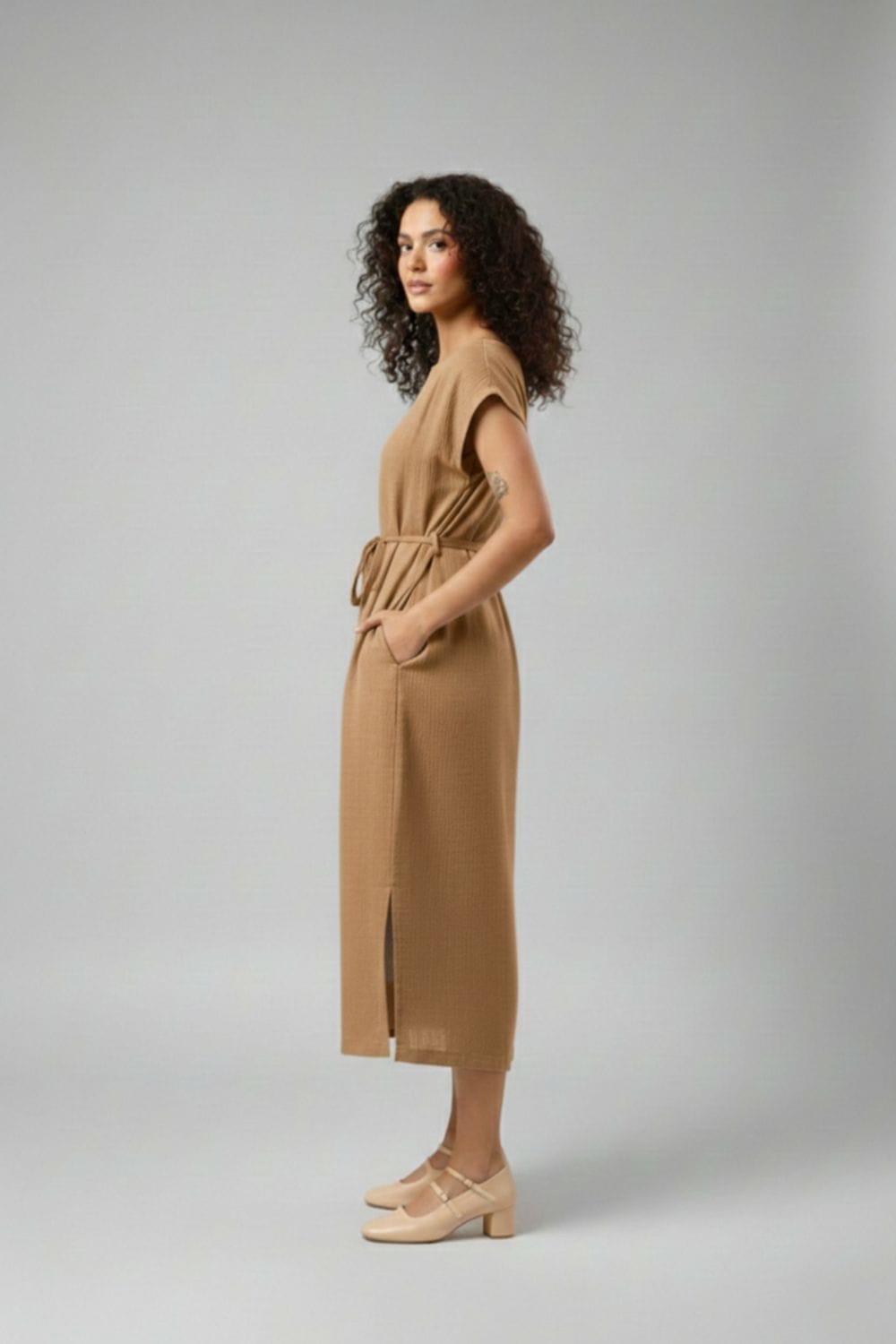 Doodlage Erna beige dress with flowy fabric and subtle detailing, displayed on a hanger against a neutral background.