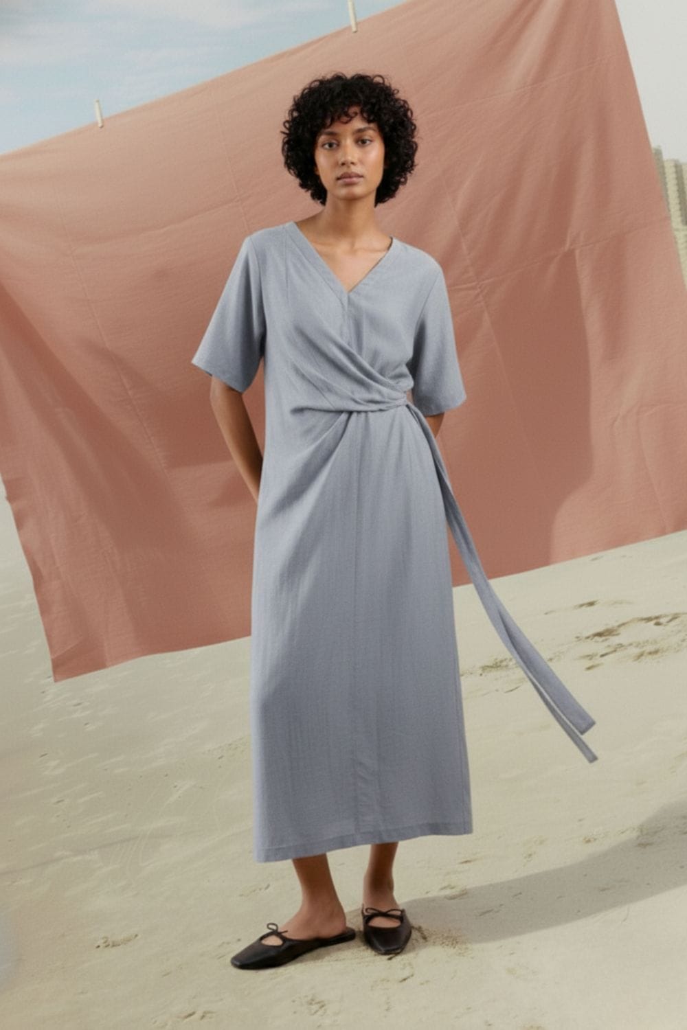 Doodlage Eden pale blue dress with short sleeves and a flowing design, displayed on a hanger against a neutral background.