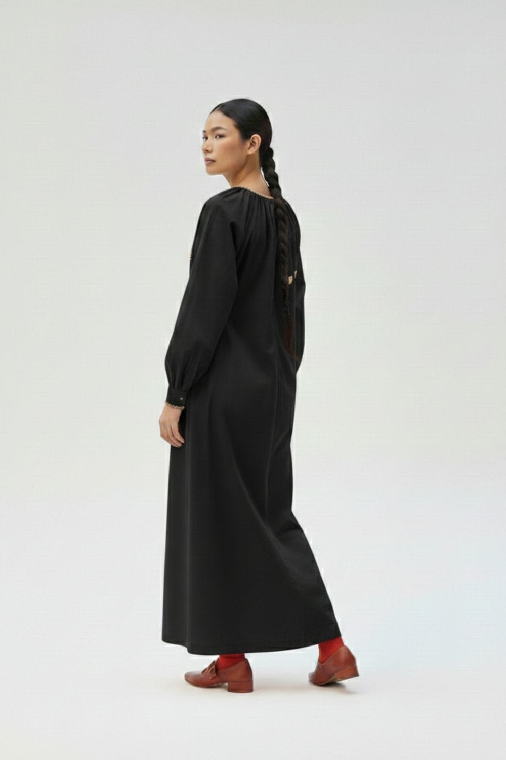 Black Astrid dress by Doodlage showing a knee-length, fitted silhouette with long sleeves and subtle detailing.