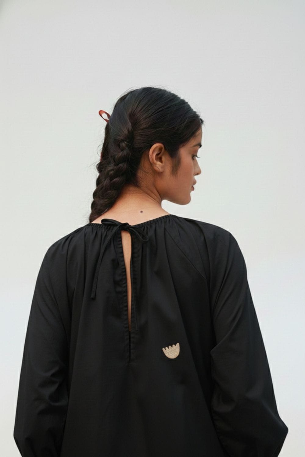 Doodlage Astrid black dress with long sleeves and a fitted silhouette, displayed on a hanger.