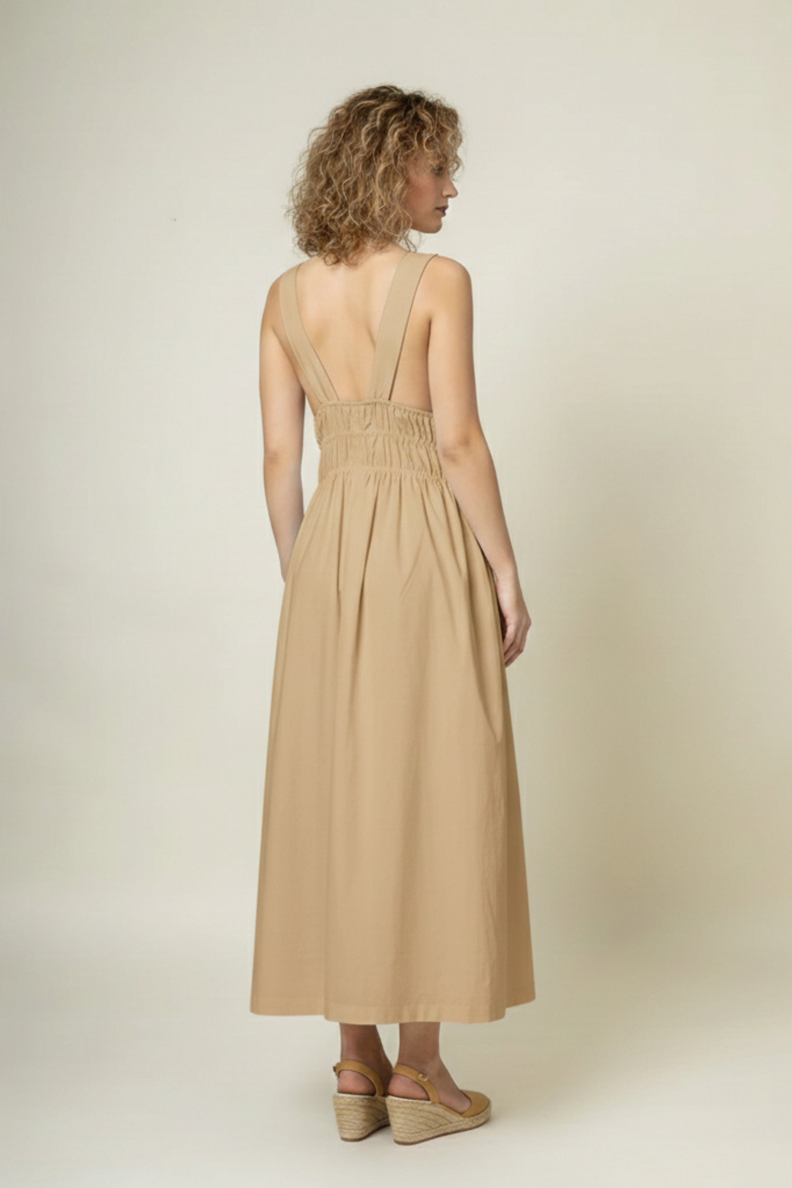 Doodlage August beige dress, lightweight fabric with subtle texture, displayed on a hanger against a neutral background.