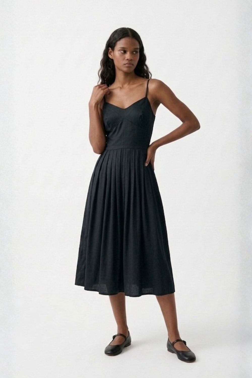 Black Doodlage Mary dress, stylish and elegant, shown hanging on a wooden hanger with a fitted silhouette and subtle detailing.