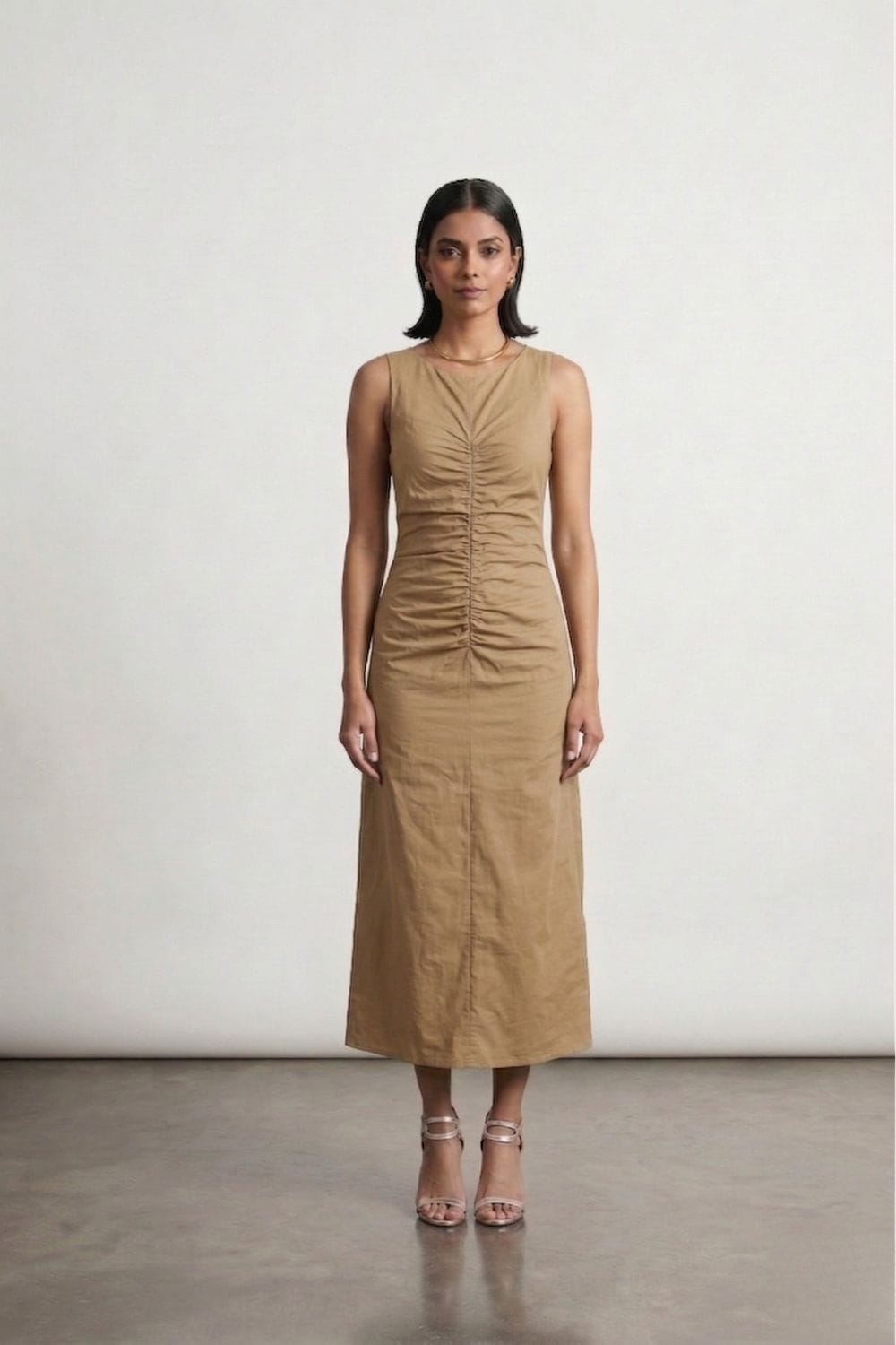 Sarah beige dress by Doodlage, sleeveless with a relaxed fit, shown hanging on a wooden hanger against a neutral background.