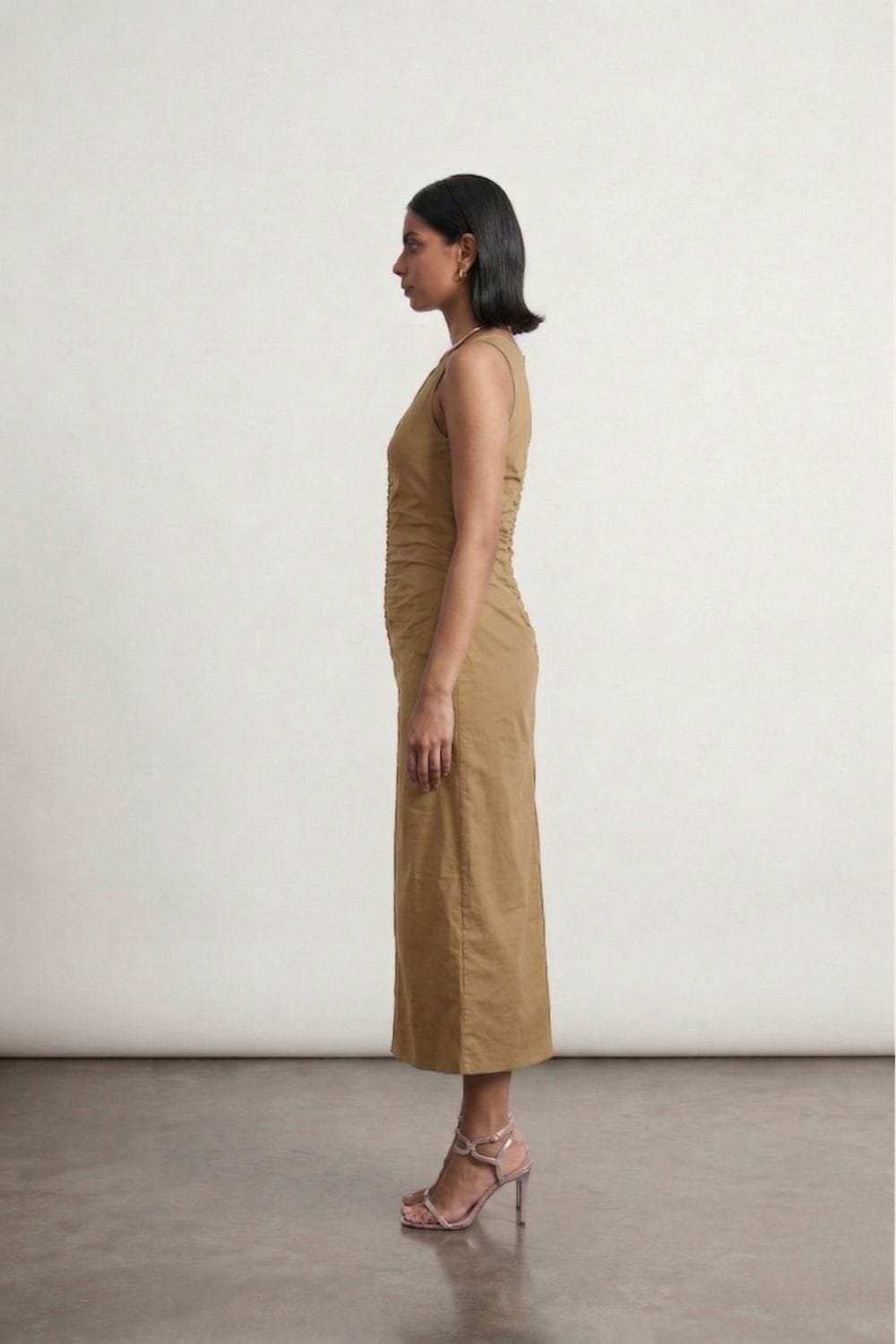 Sarah beige dress by Doodlage, sleeveless with a relaxed fit, shown hanging on a wooden hanger against a neutral background.