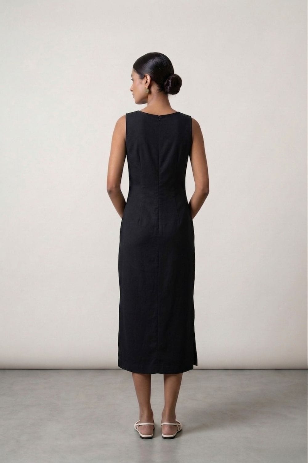 Black Sarah dress by Doodlage, stylish sleeveless dress with a fitted silhouette and subtle detailing, shown on a hanger.