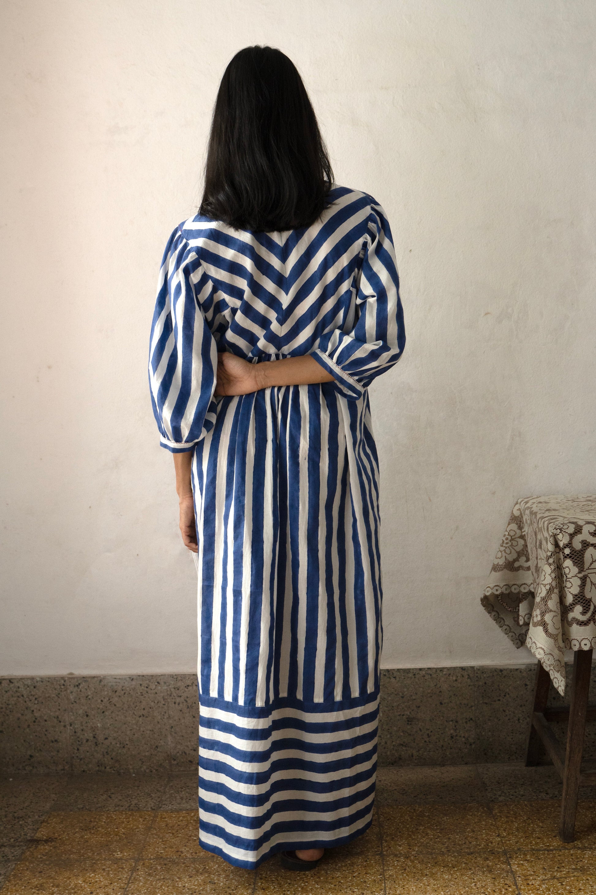 Deeta Nidar tea dress with floral pattern, short sleeves, and V-neck, displayed on a hanger against a white background.
