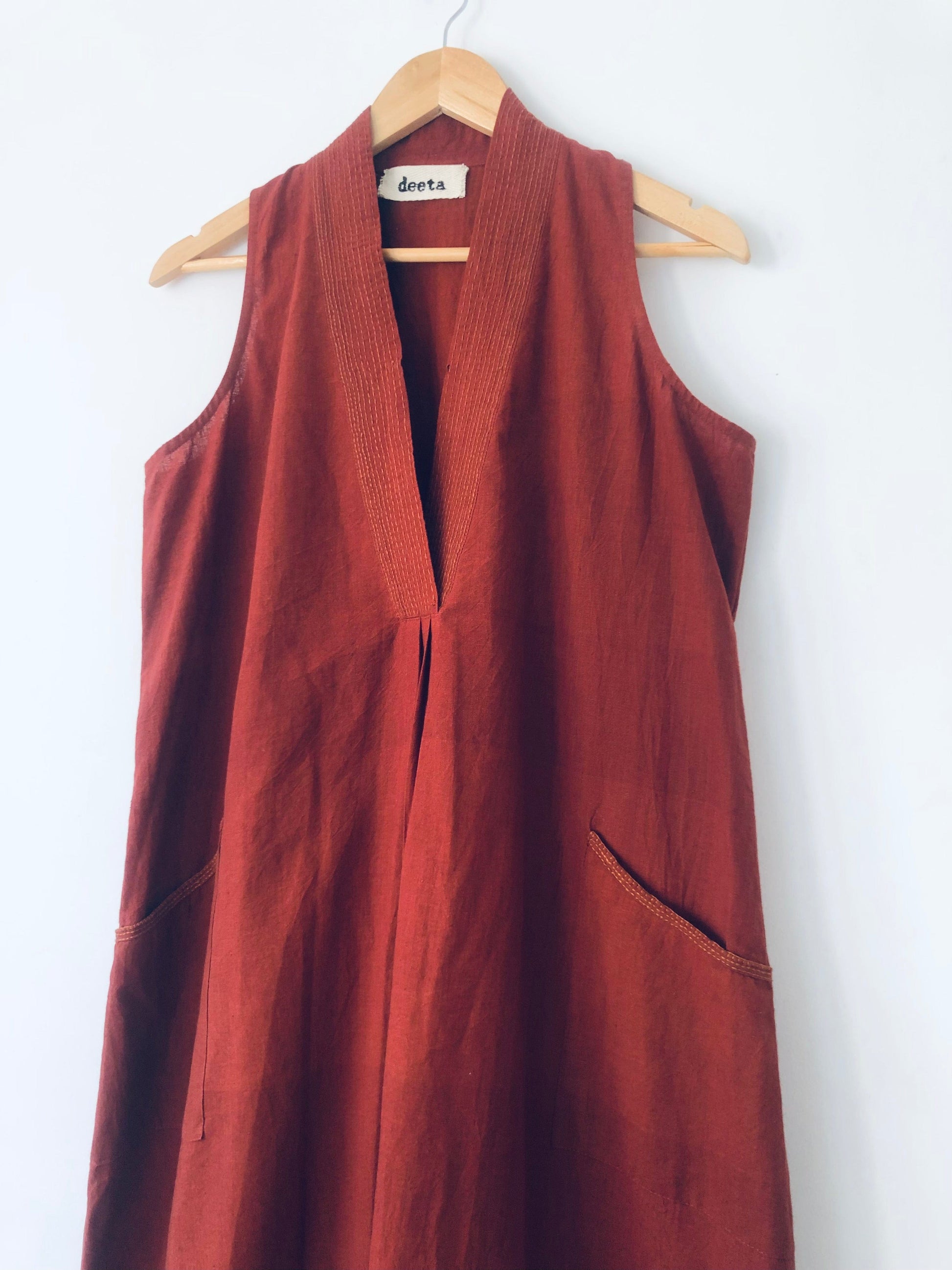 Deeta Bay dress displayed on a hanger with flowing fabric and vibrant colors, perfect for stylish summer wear.
