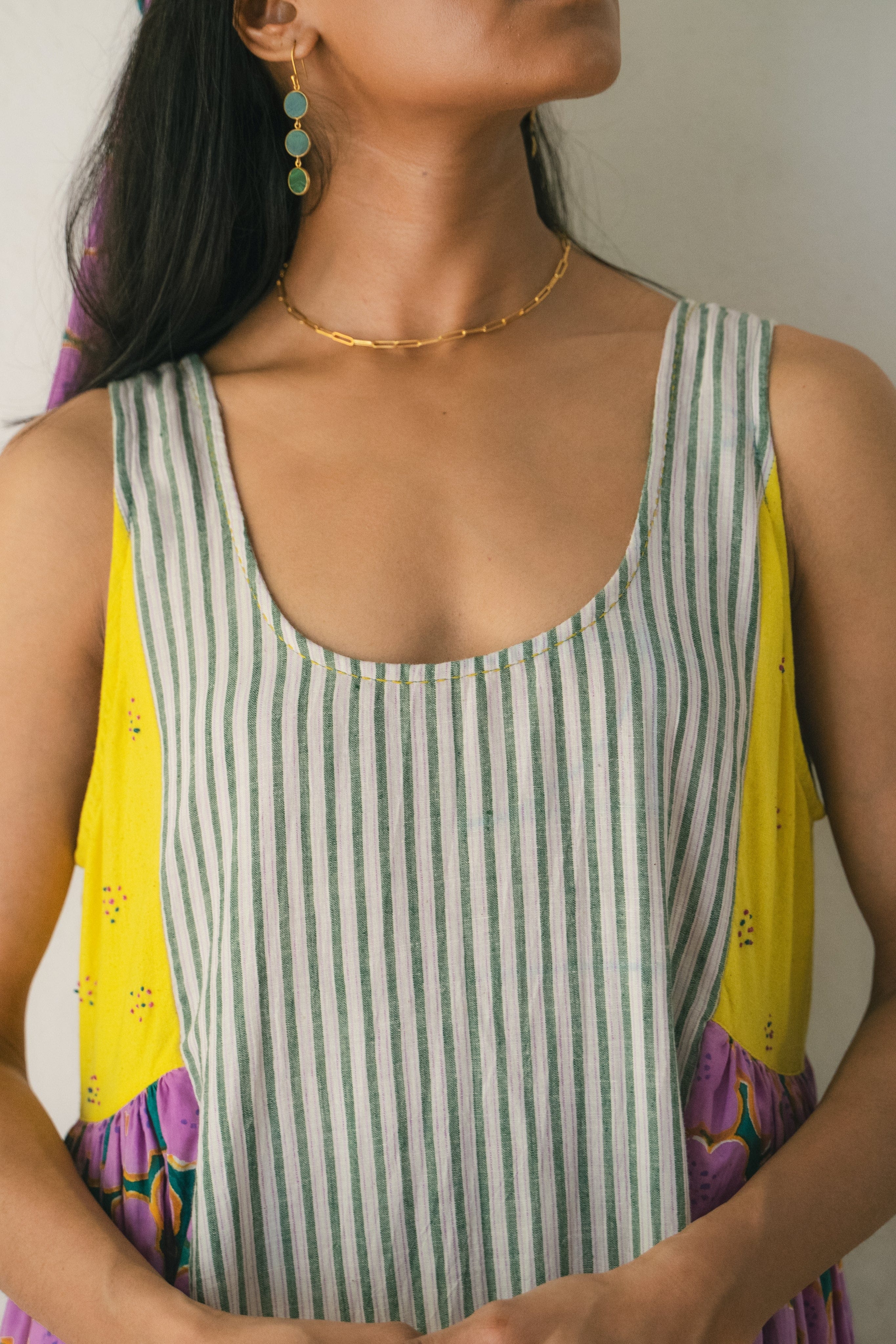 Deeta blooming patchwork dress showing a colorful, floral design with a fitted waist and flowing skirt.