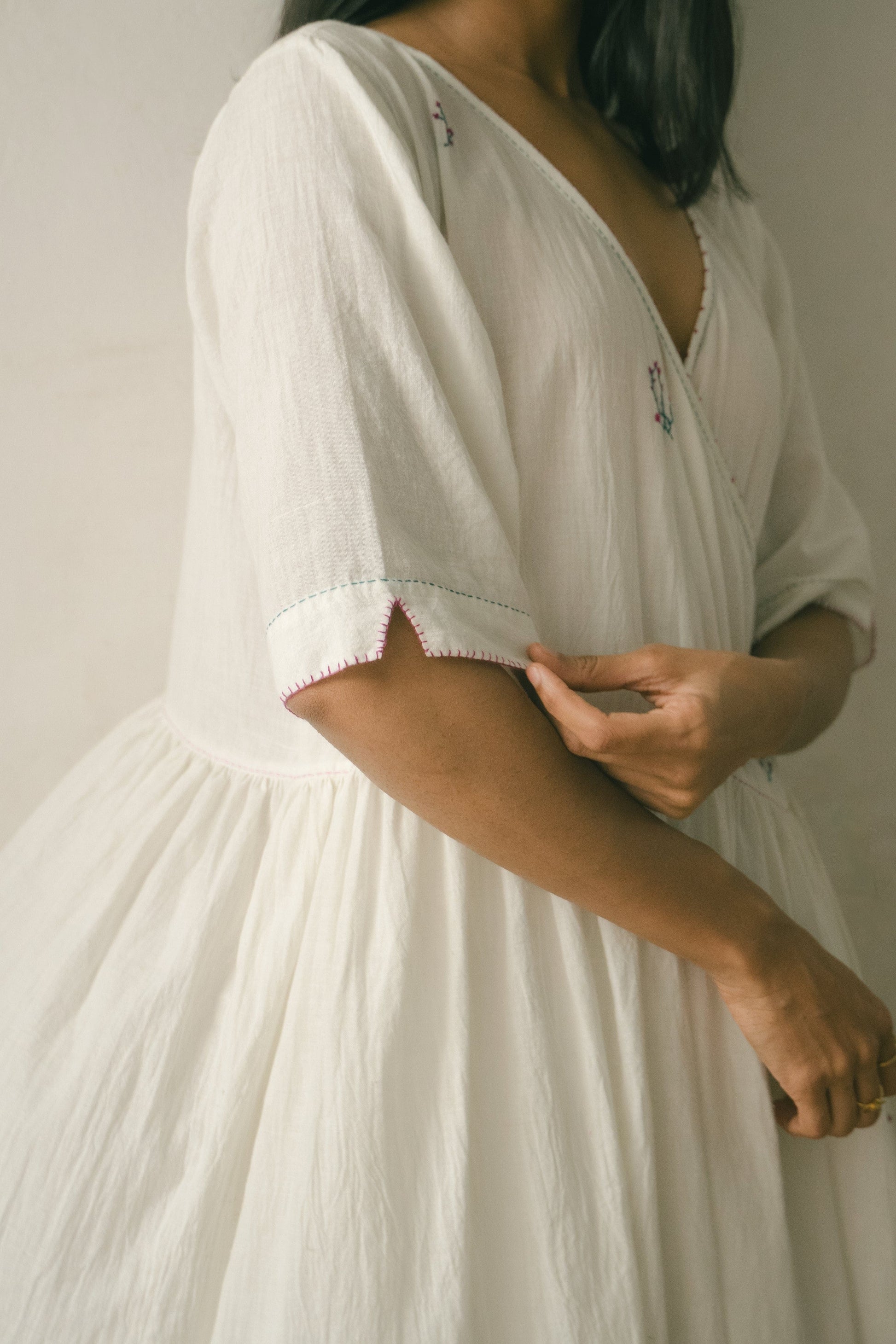 Deeta Sara tunic dress in soft fabric with a relaxed fit, featuring a V-neckline and long sleeves, displayed on a hanger.