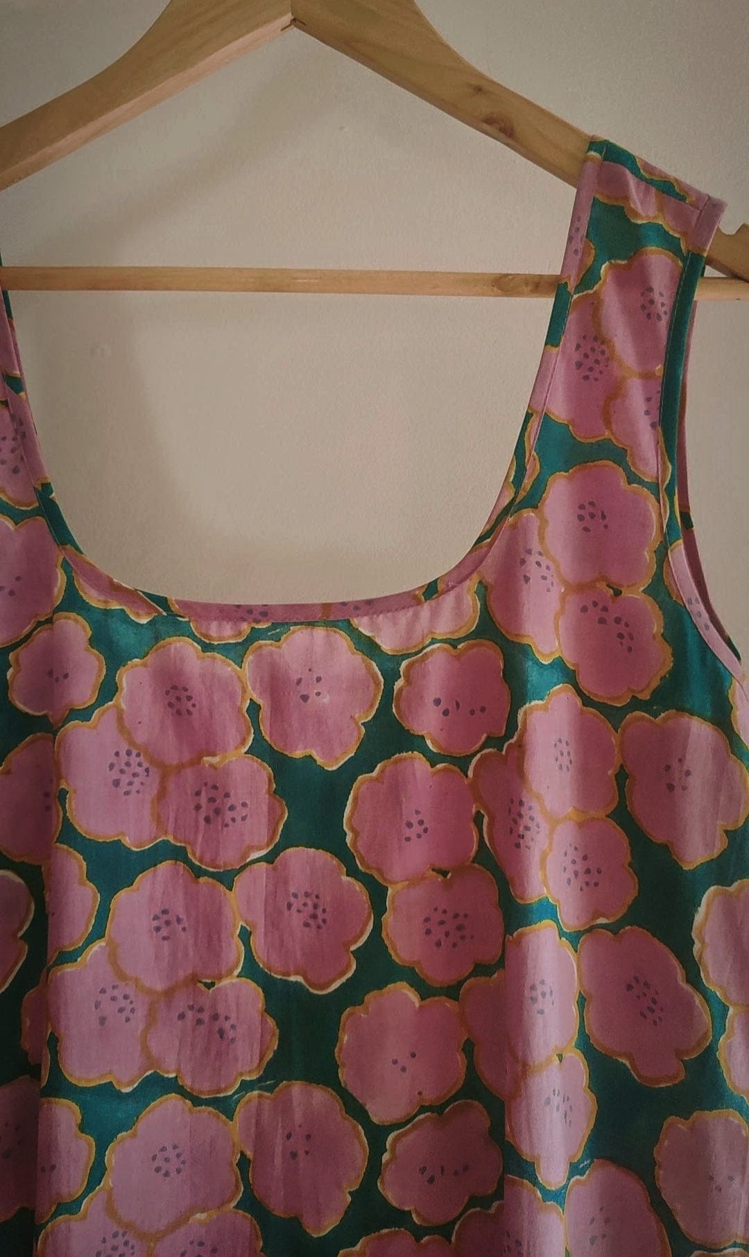 Deeta Clover slip dress featuring a flowy, lightweight fabric with a fitted bodice and adjustable straps, shown on a hanger.