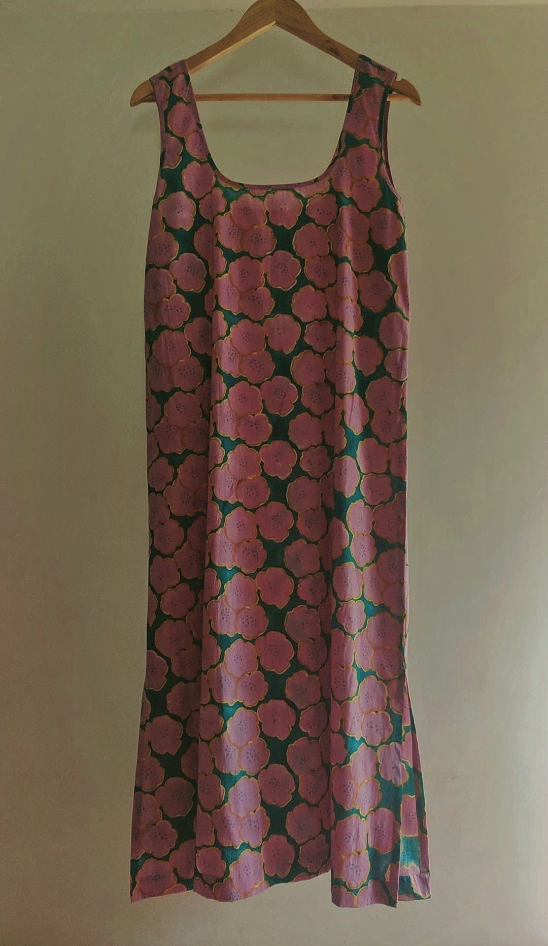 Deeta Clover slip dress displayed on a hanger, showcasing its lightweight fabric and simple, elegant design.