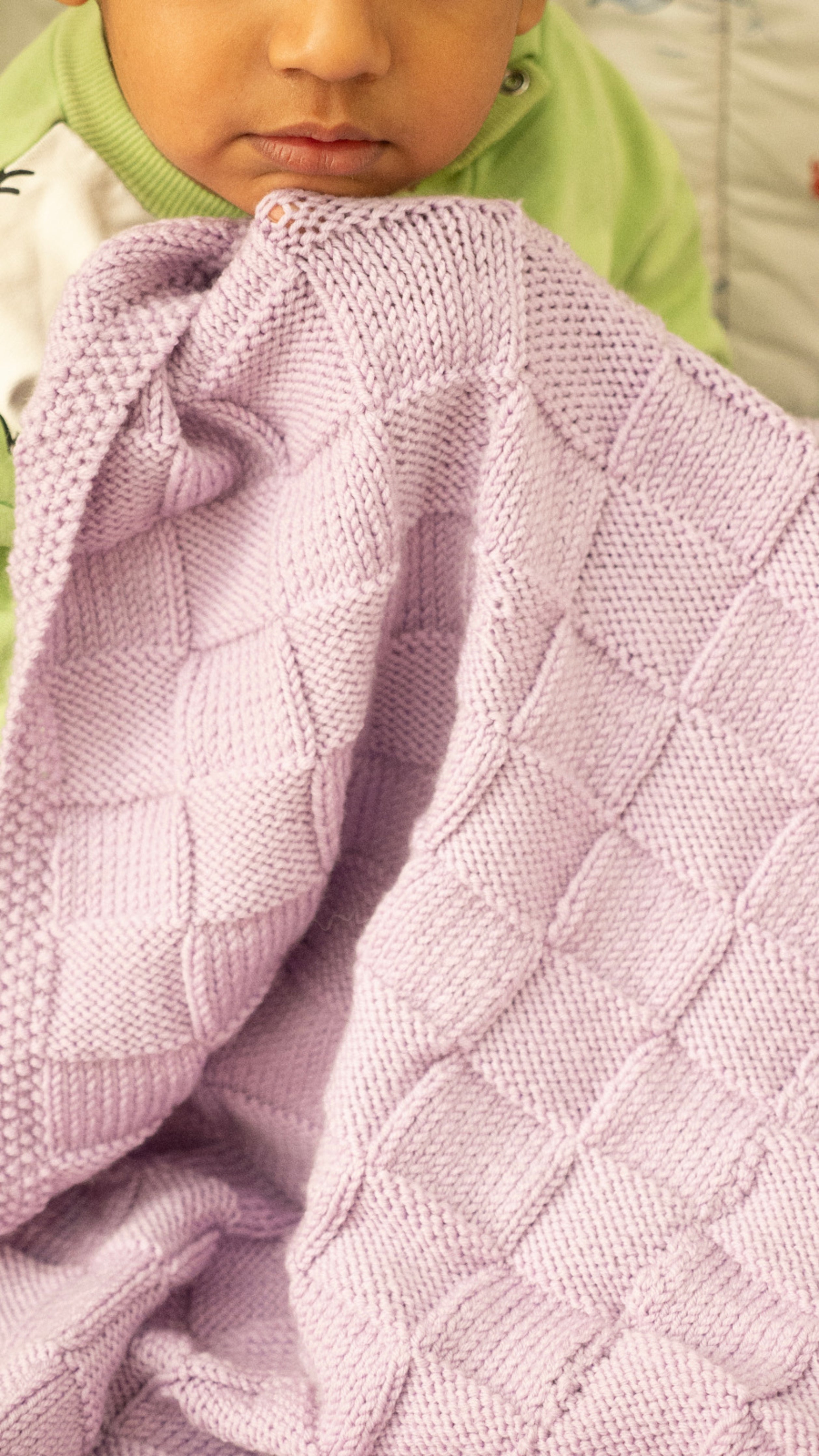 Purple Merino wool blanket by Masaya Home, soft and cozy with a plush texture, spread out on a neutral surface.