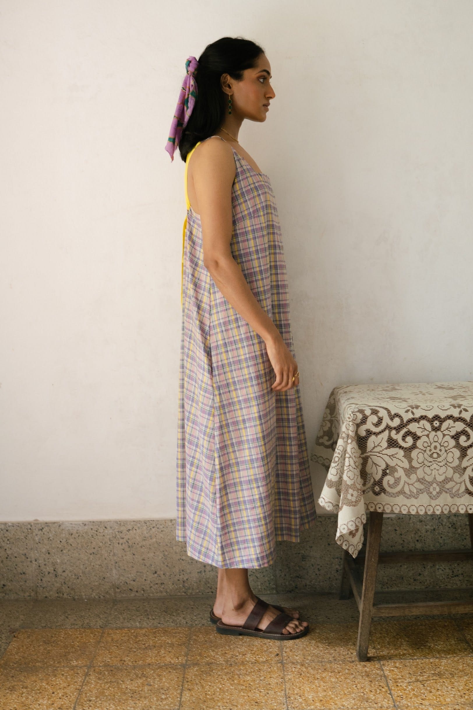 Deeta Meadow dress with floral print, sleeveless design, and flowing fabric displayed on a hanger.
