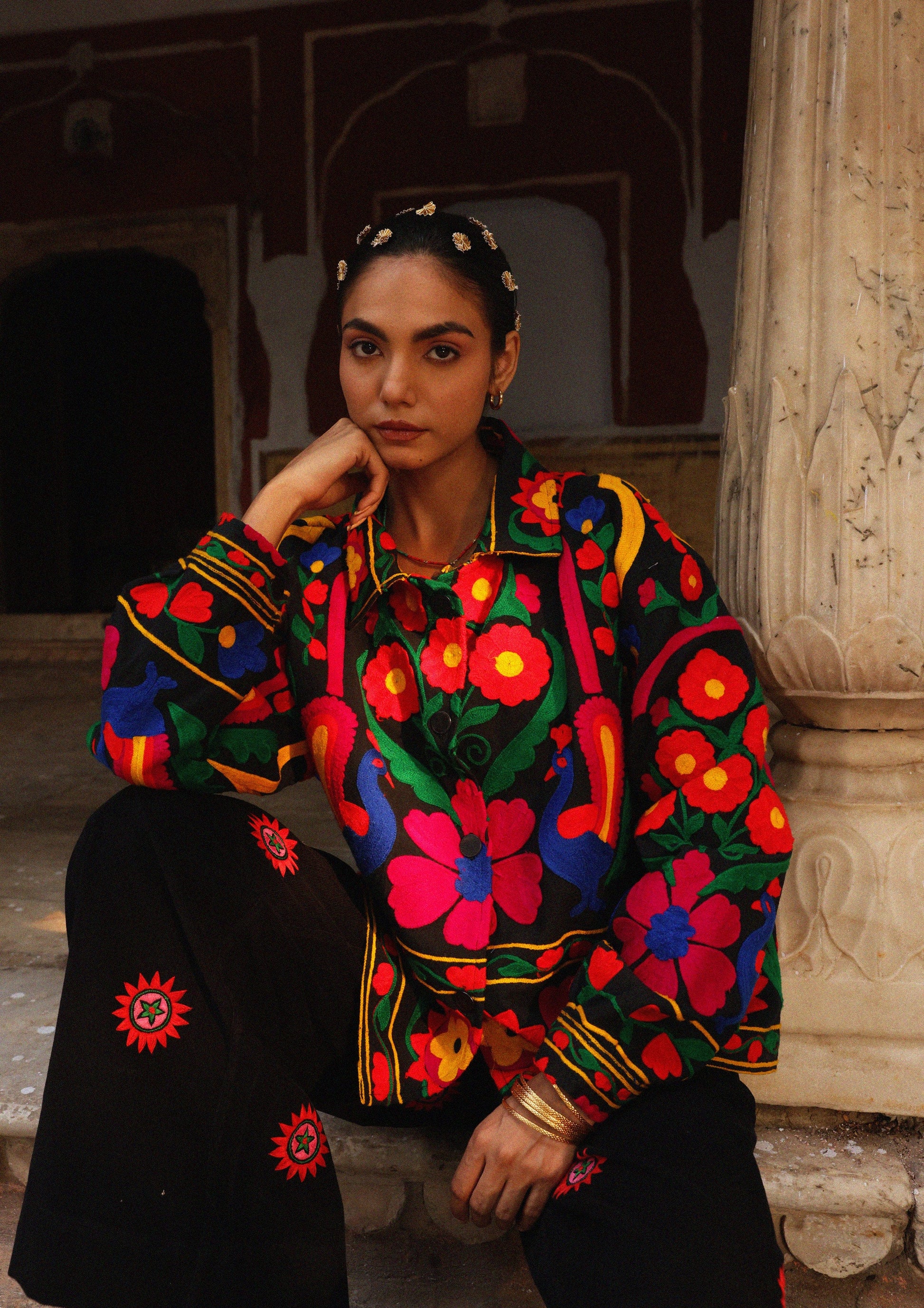 The Raw India Jaipur jacket with intricate peacock embroidery, showcasing vibrant traditional textile design and detailed craftsmanship.