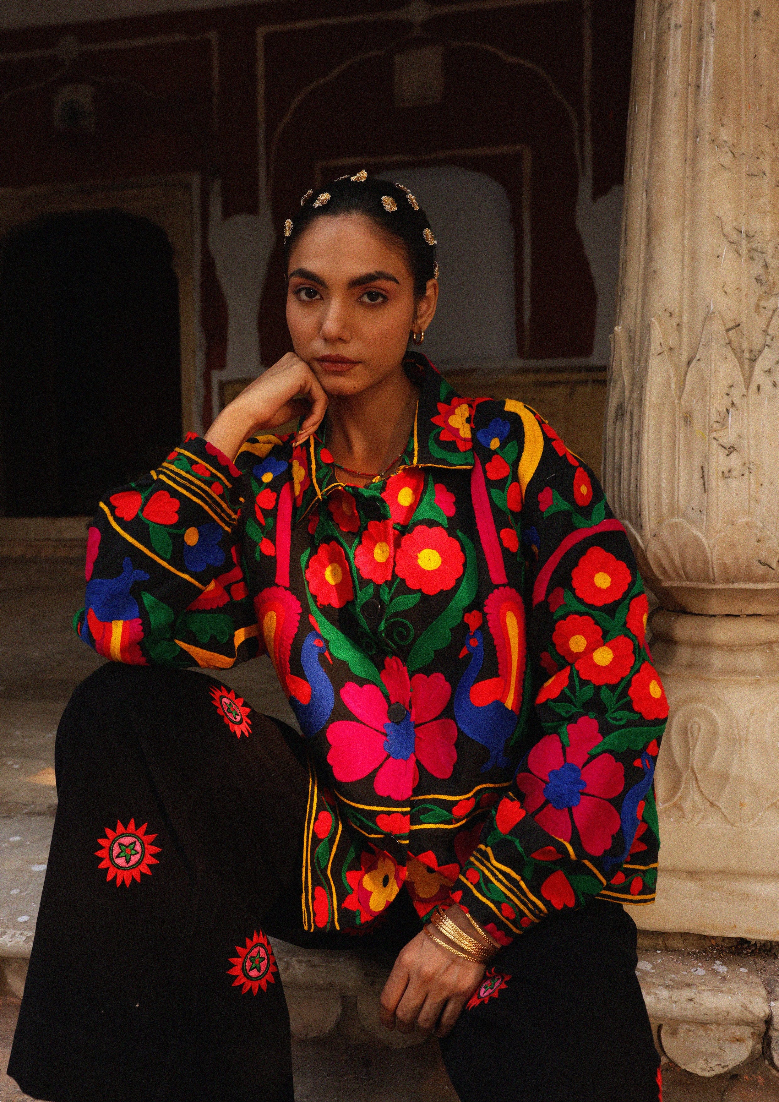 The Raw India Jaipur jacket with intricate peacock embroidery, showcasing vibrant traditional textile design and detailed craftsmanship.