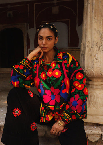 The Raw India Jaipur jacket with intricate peacock embroidery, showcasing vibrant traditional textile design and detailed craftsmanship.