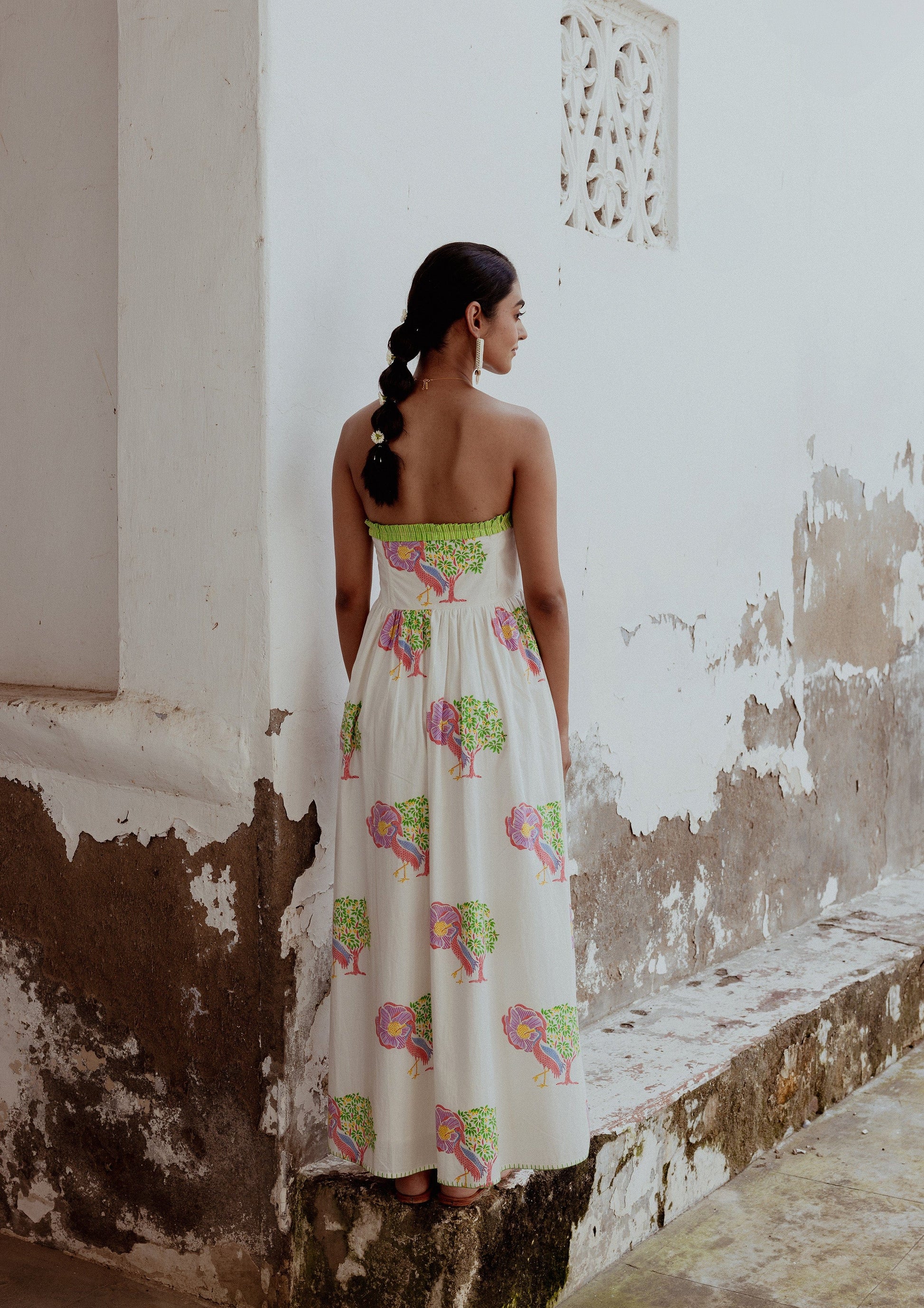 The Raw India Jobner Dress Saras Crane featuring traditional print and vibrant colors, displayed on a hanger against a neutral background.