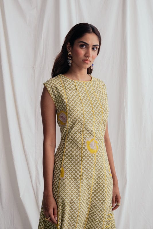 JODI Panna panel dress featuring a flowing silhouette with panel details and a V-neckline, worn by a model with styled hair and accessories.