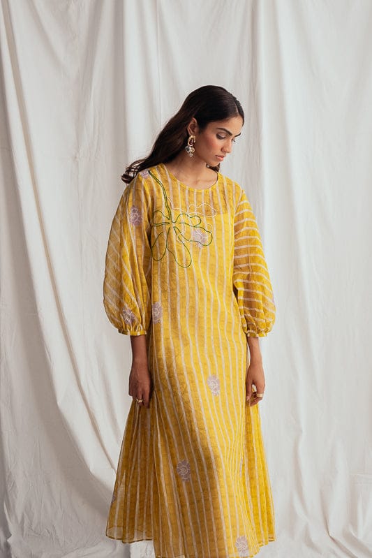 JODI Dhoop peasant dress featuring flowy fabric and boho style, displayed on a model with earthy tones and relaxed fit.