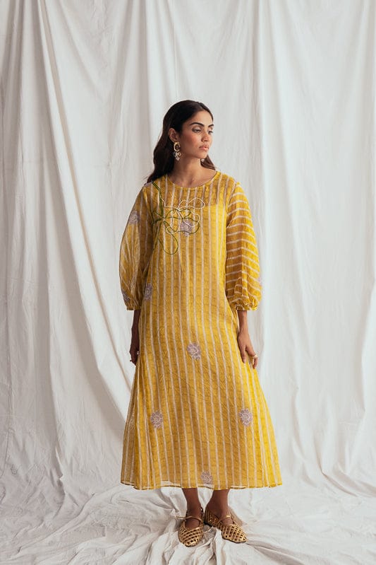 JODI Dhoop peasant dress, flowy bohemian style with intricate patterns and relaxed fit, displayed on a model in a lookbook setting.