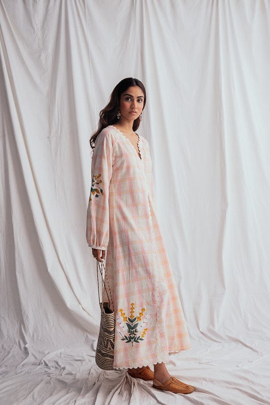 JODI Chataai peasant dress with relaxed fit, earthy tones, and flowy fabric, displayed on a model in a natural outdoor setting.
