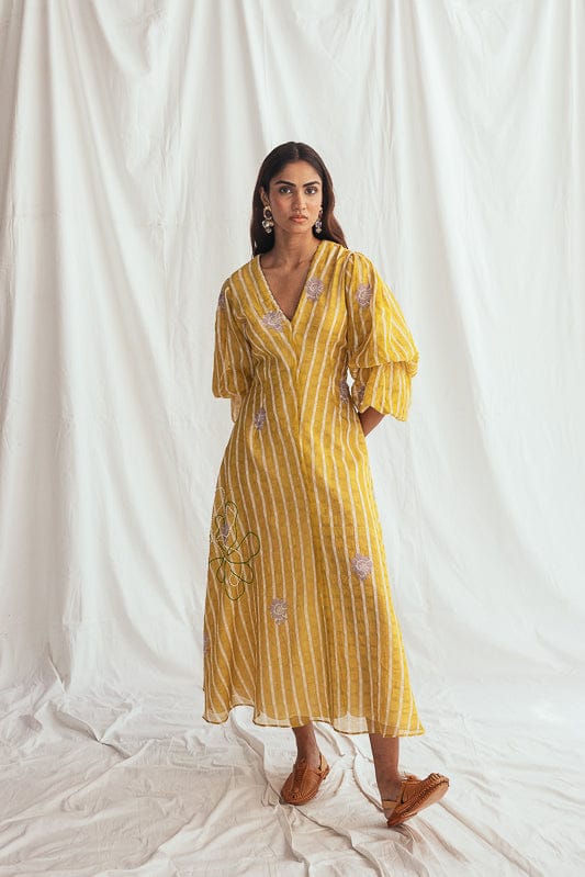 JODI Dhoop dress in vibrant fabric, featuring intricate embroidery and flowy silhouette, shown on a model in a fashion lookbook image.