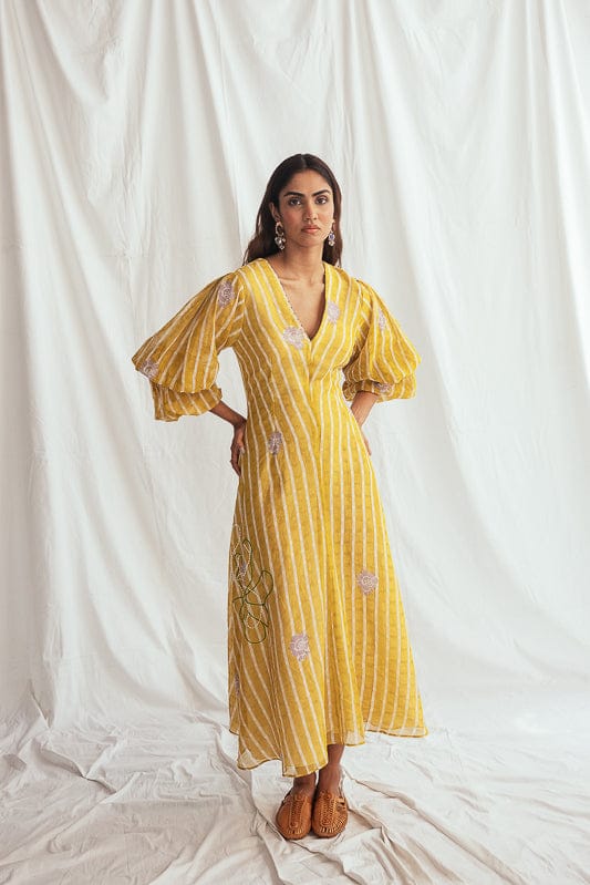 JODI Dhoop dress displayed on a model with intricate embroidery and flowing fabric, showcasing elegant traditional dress design.