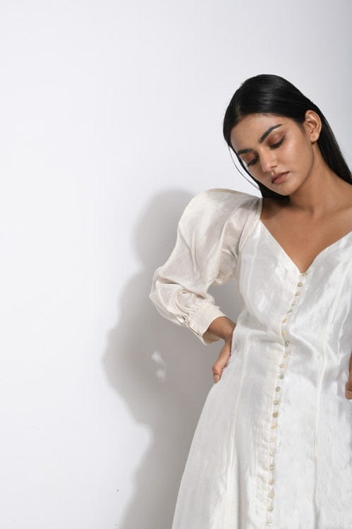 Pearl white silk dress by Theloomart, elegant and flowing with smooth fabric and stylish design for formal occasions.