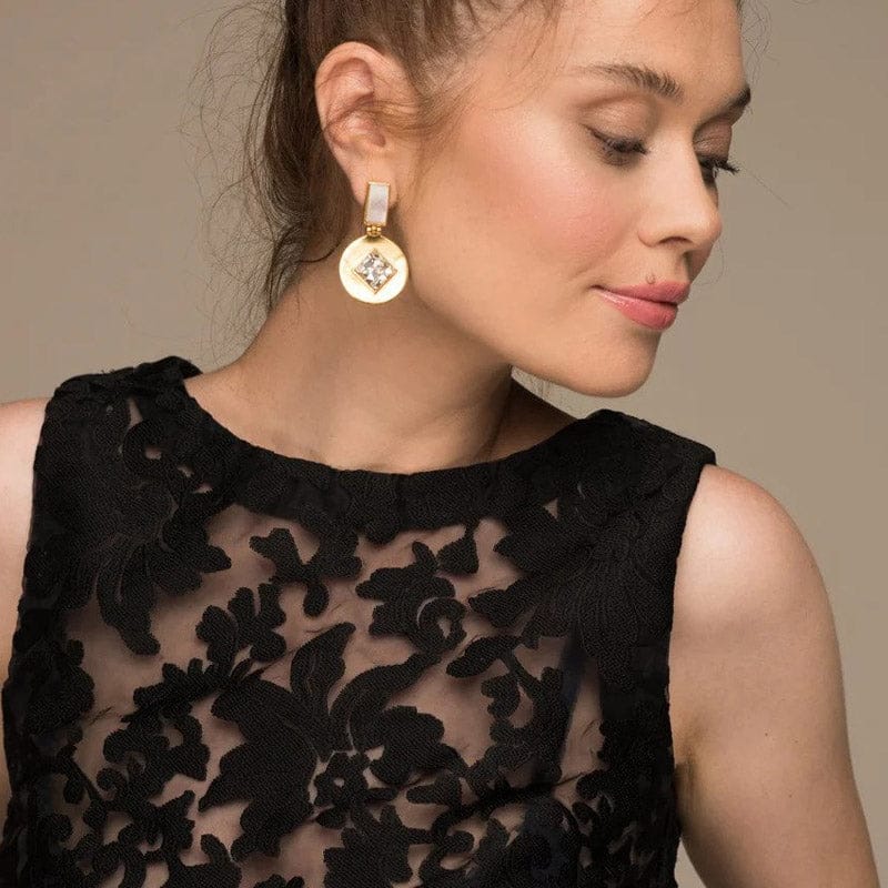 Close-up of Bombaybirds Mya earrings, silver hoop earrings with intricate design, hanging from earlobes.