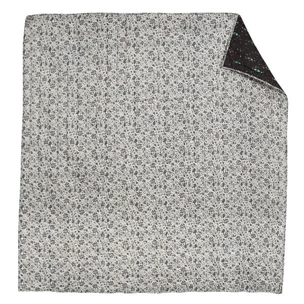 Galaxy Garden grey reversible blanket by Bombaybirds, showing soft fabric with galaxy and floral patterns in a living room setting.